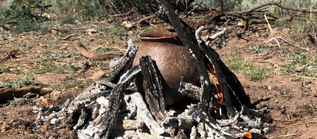 Primitive pottery being fired in an open fire