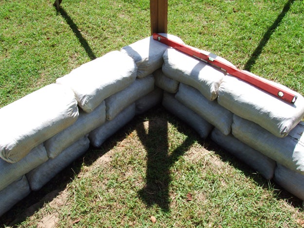 Earthbag construction showing stacked bags and tamping process
